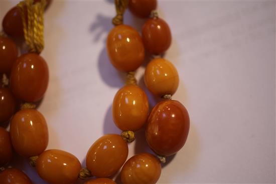 A single strand graduated amber oval bead necklace,